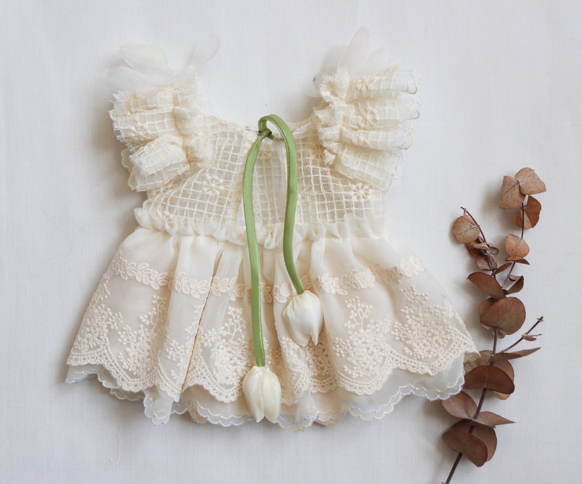 Newborn girl ivory romper with embroidered lace bodice, chiffon skirt, and ruffled lace accents – ideal for photoshoots