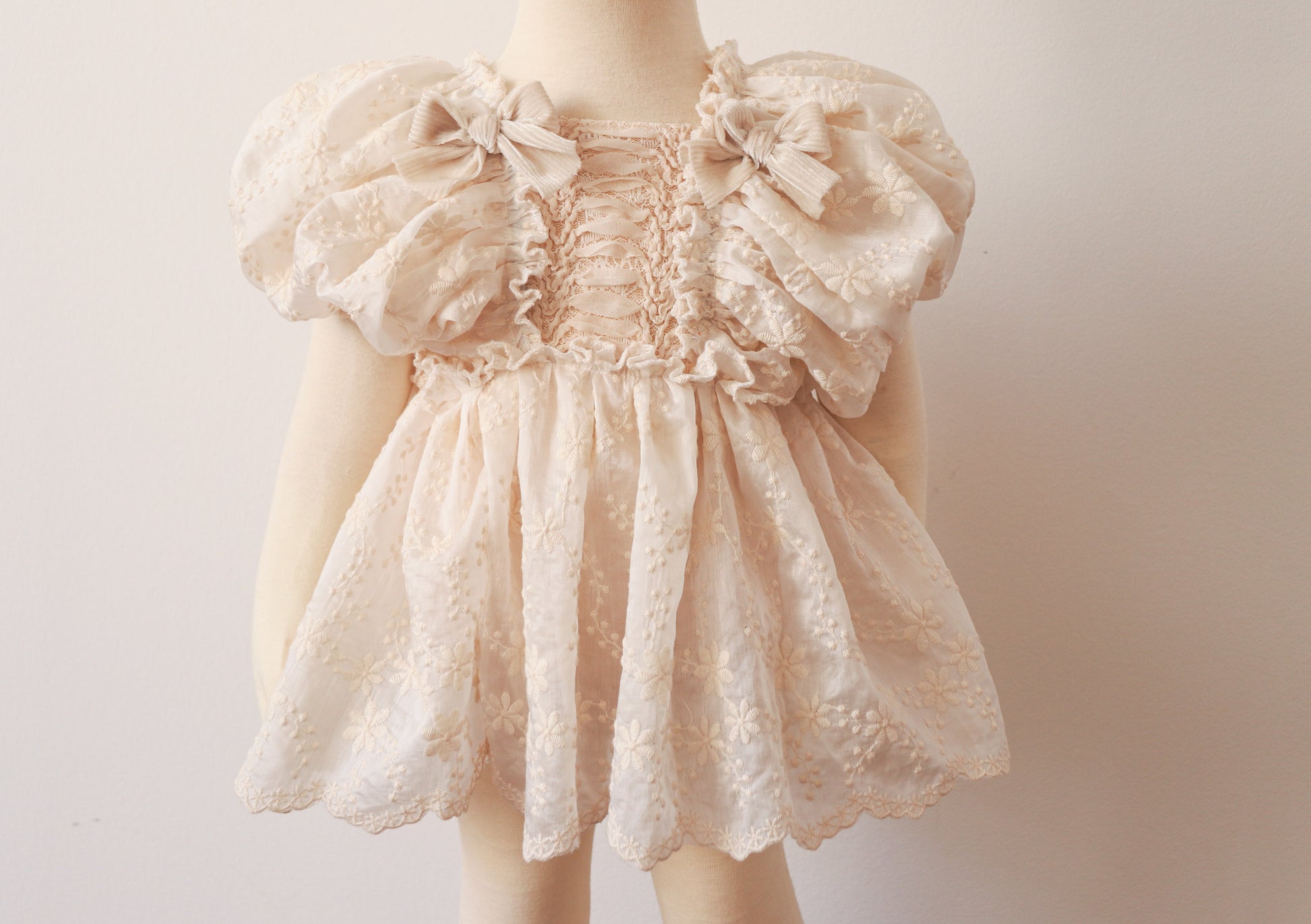 "A delicate light beige chiffon dress for girls, featuring puffy sleeves and vintage lace details, perfect for baptisms, birthdays, and boho-inspired photoshoots."