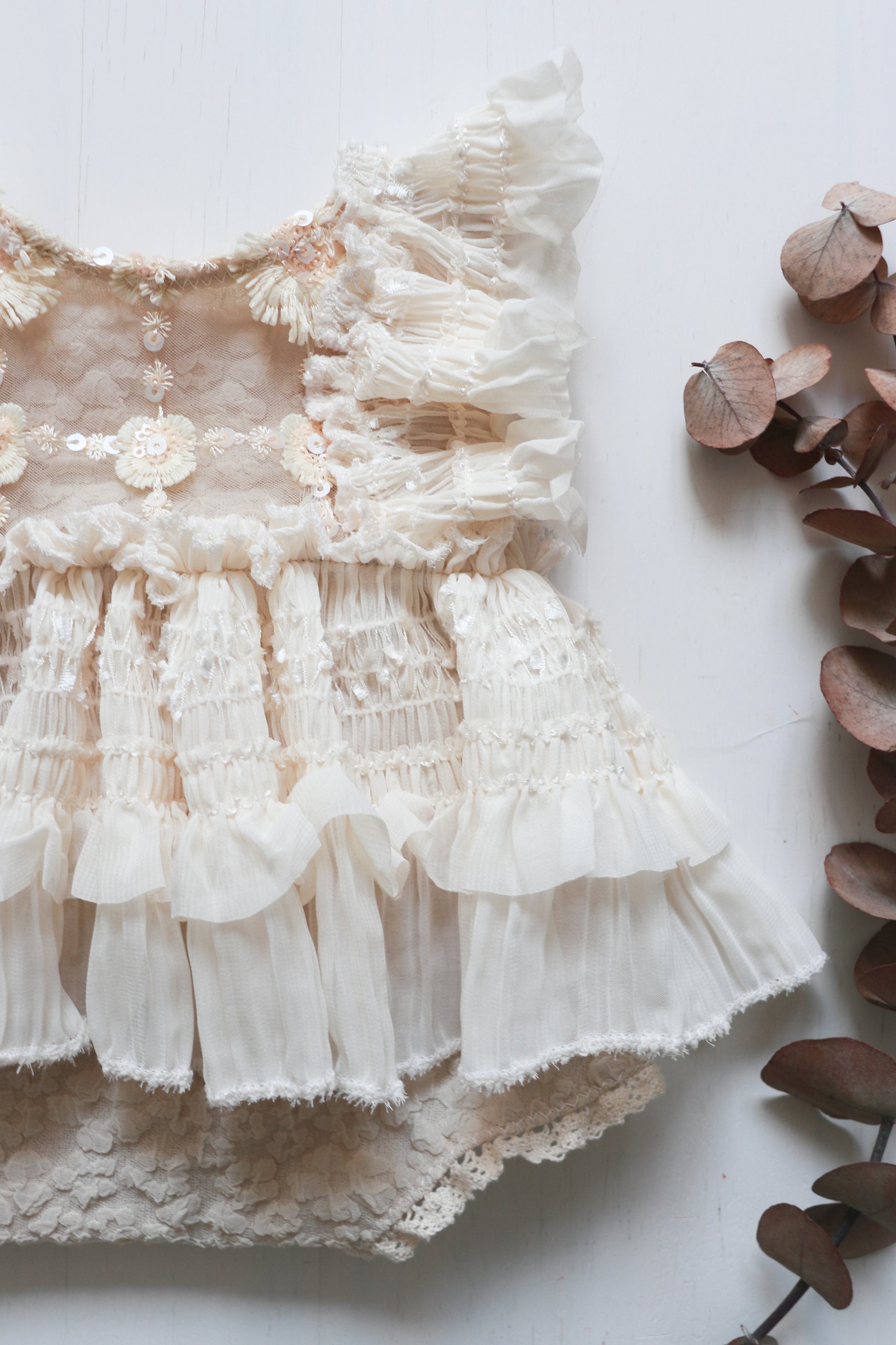 Elegant newborn girl romper with soft cotton fabric, delicate floral details, and a chiffon skirt, perfect for photo shoots and newborn sessions.