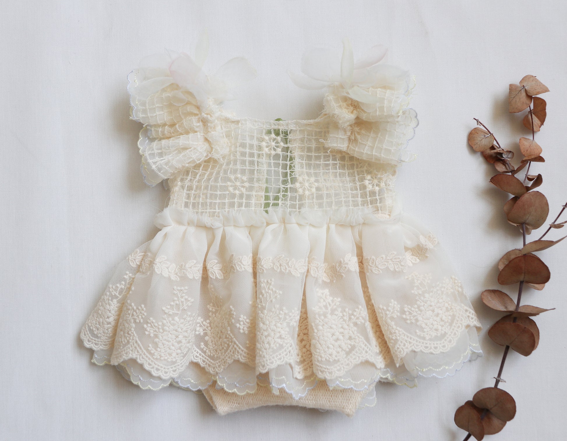Elegant newborn romper dress featuring floral embroidery, chiffon layers, and delicate ivory straps for photo sessions