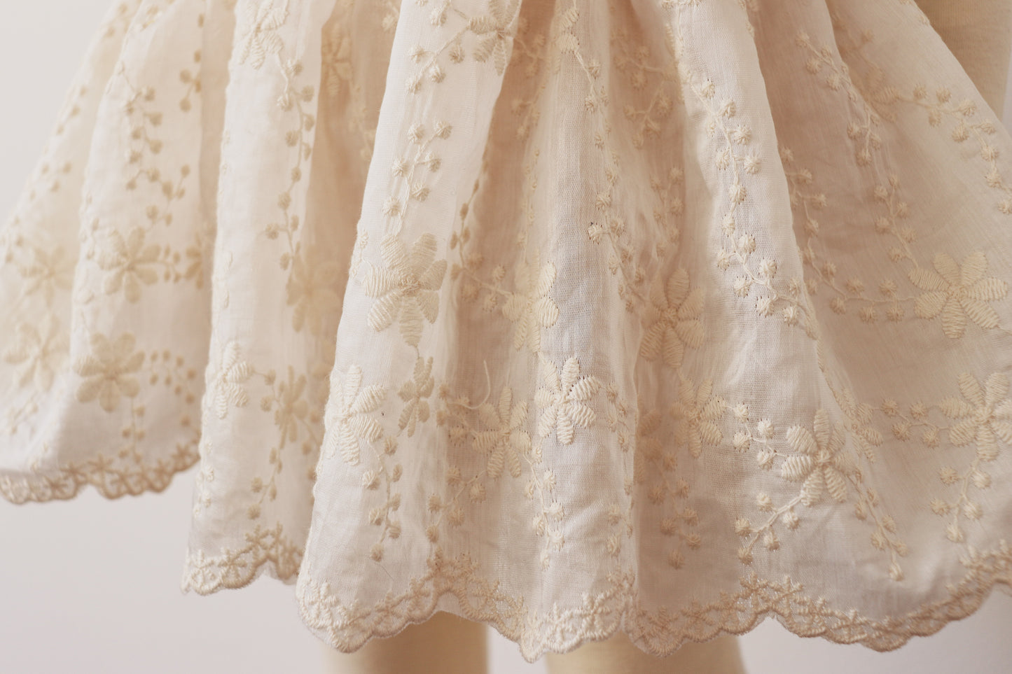 "Little girl wearing a dreamy beige chiffon dress with vintage lace bodice and puffy sleeves, capturing elegance and charm in a boho outdoor setting."