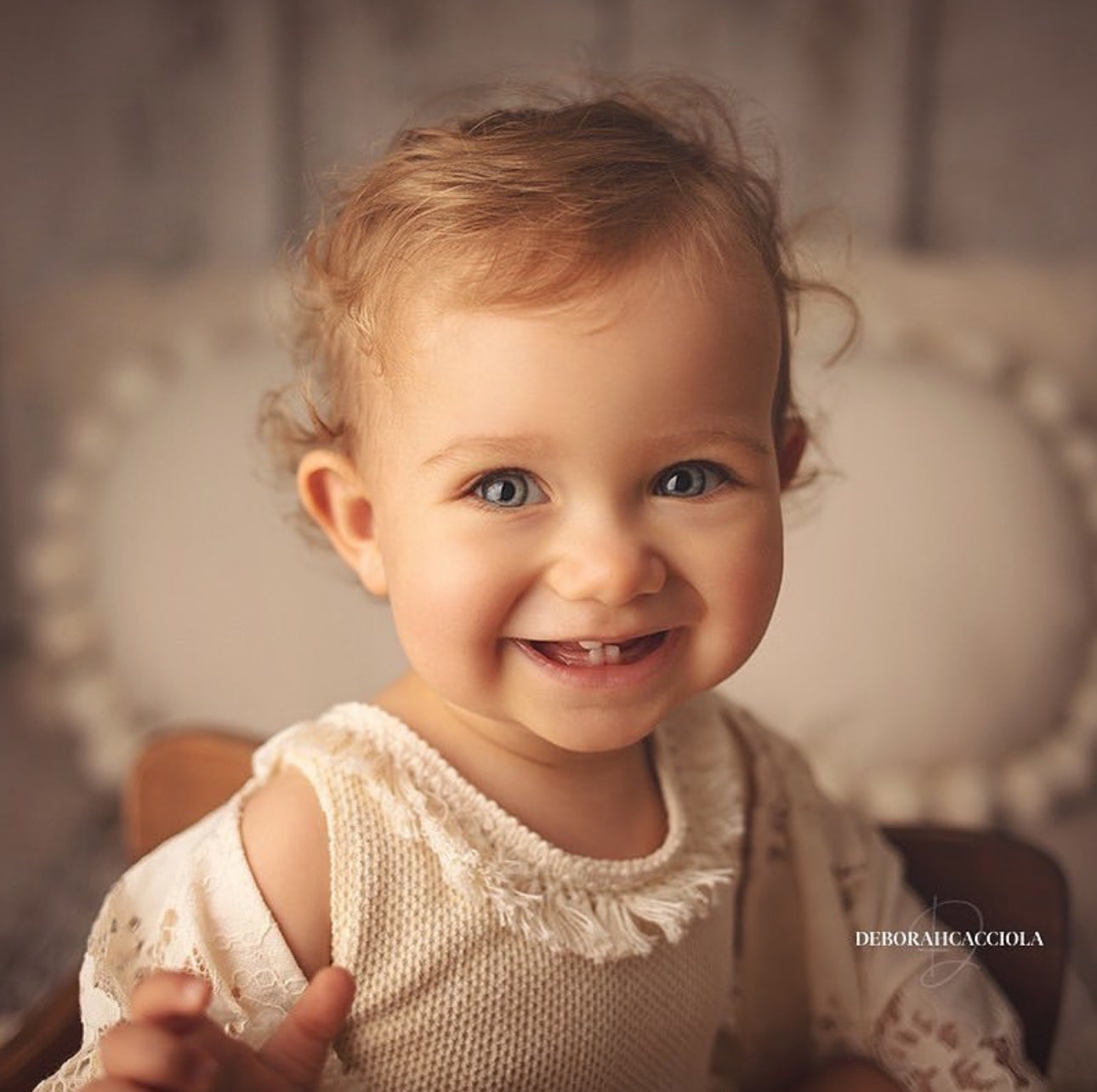 Smiling toddler girl wearing a beige knitted top and lace sleeve boho girl photoshoot outfit by FLEUR MARGOT