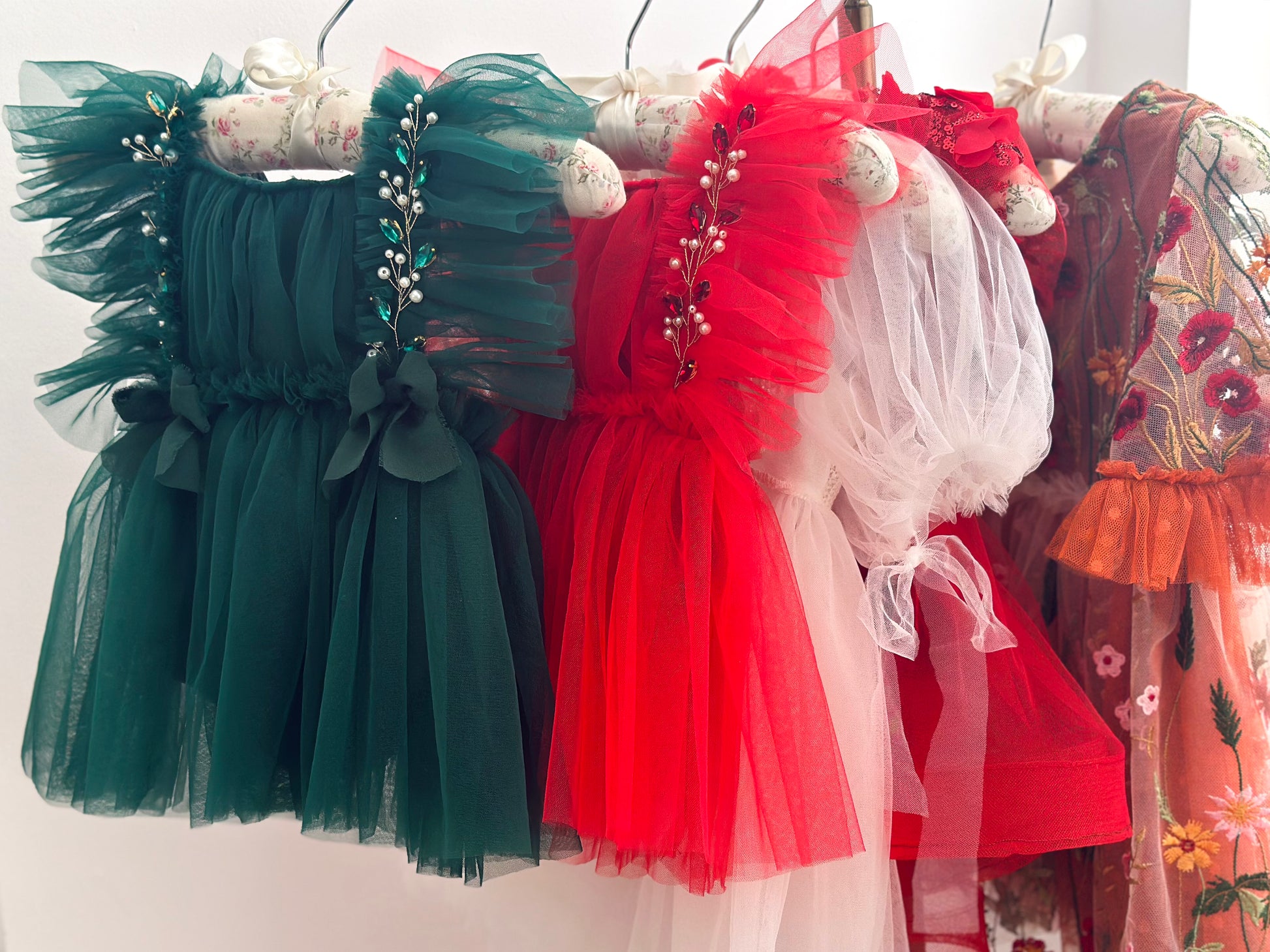 Infant rhinestone Christmas outfit in green and red tulle dresses with decorative pearl accents
