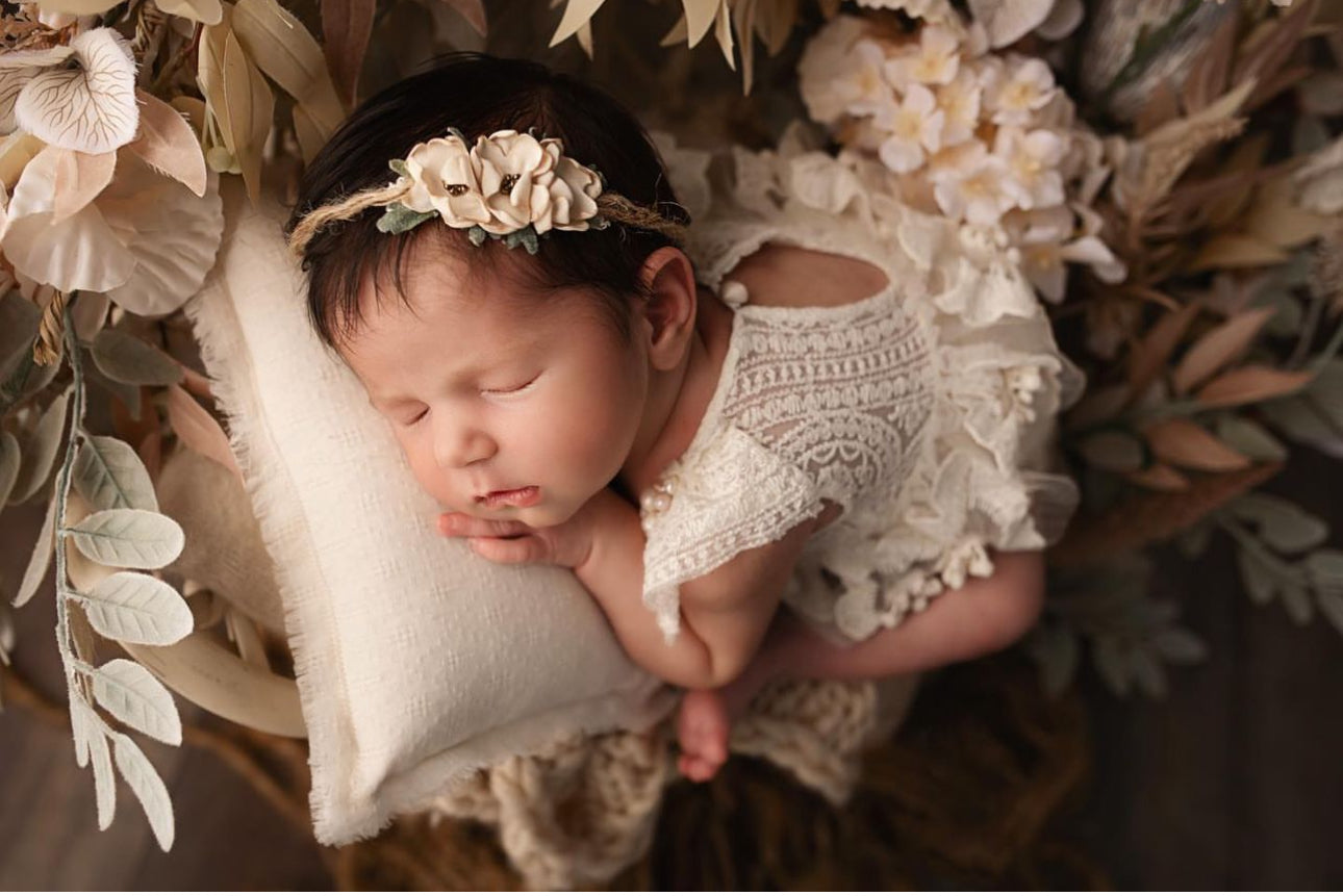 Newborn baby sleeping peacefully wearing a newborn photography prop dress by FLEUR MARGOT with floral headband