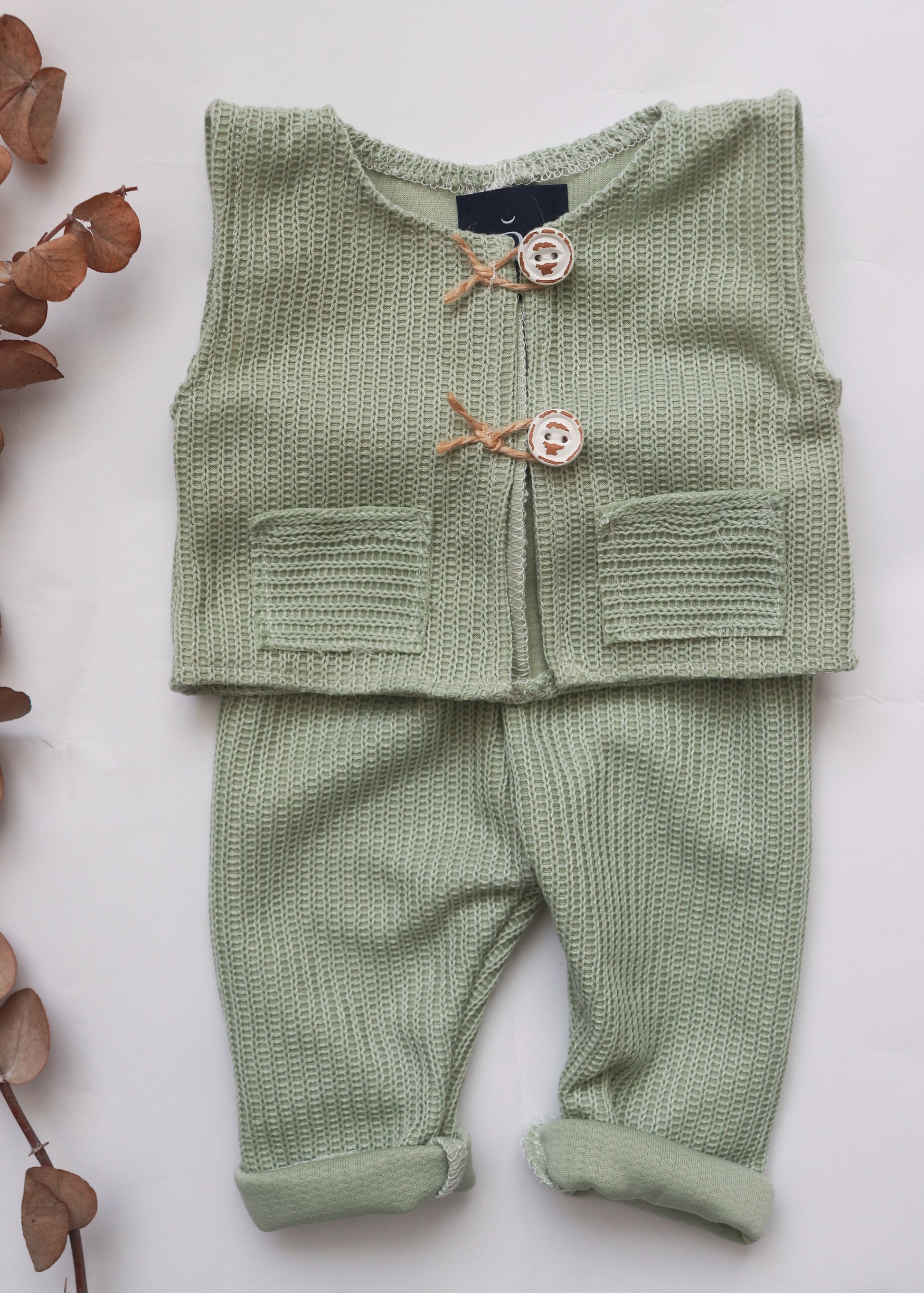 Soft green newborn photography prop outfit with knitted vest and matching pants for adorable photos