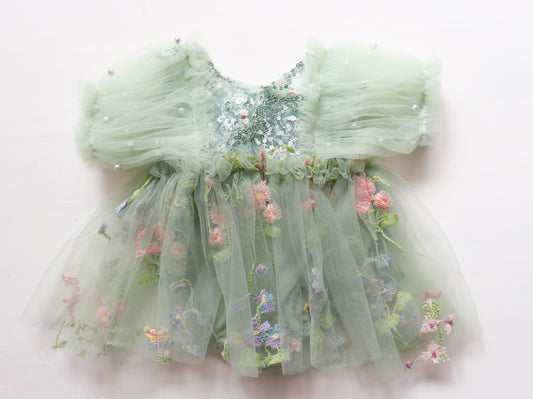 Newborn girl’s romper dress with puffy sage green tulle sleeves, colorful sequin bodice, and matching pantie