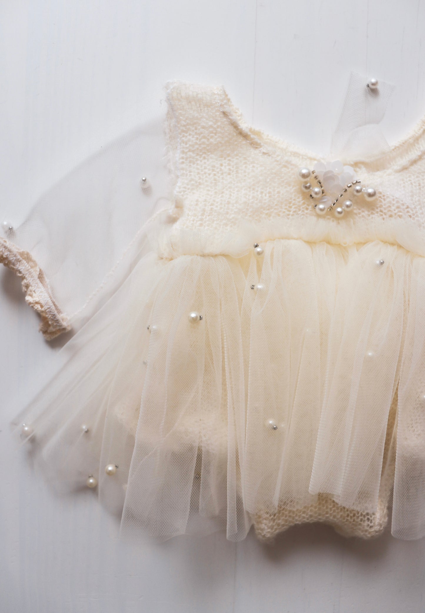 Made from soft wool, these dresses provide warmth and coziness. The delicate pearls and tulle in a sophisticated cream color add a touch of elegance, perfect for special occasions.