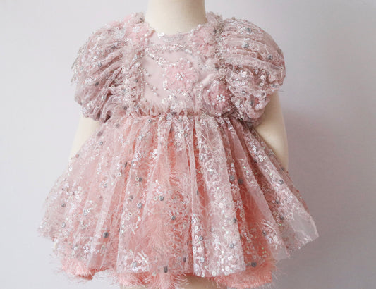 Pink girl’s dress with velvet bodice, beaded flowers, and sparkling sequin skirt with feather-style lining