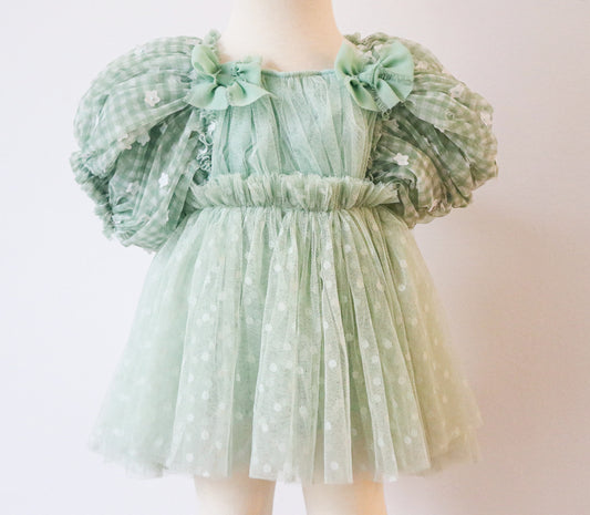 Close-up of a pastel green dress for girls, featuring delicate white floral puffy sleeves, ideal for springtime photoshoots and special outdoor sessions
