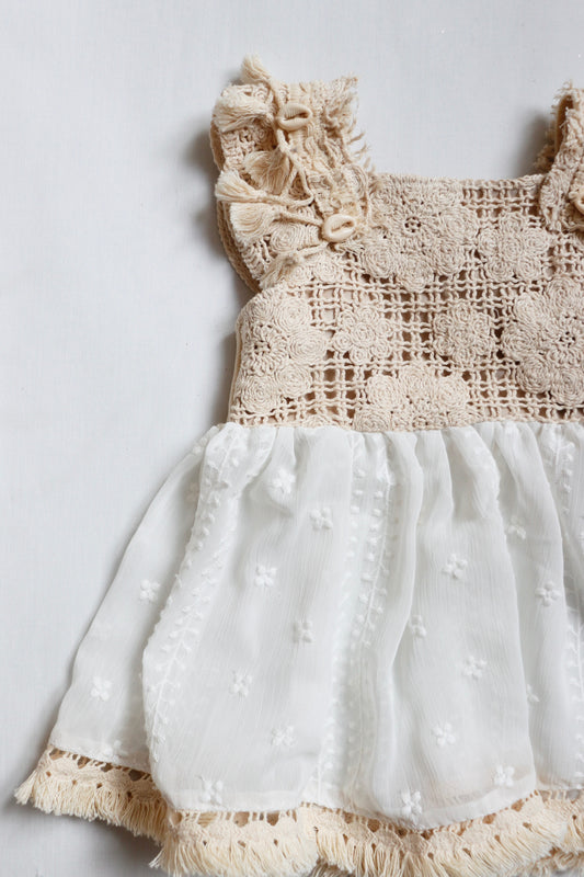 "Beige boho girl dress with a chiffon skirt, fringe shoulder straps adorned with shells, and a matching diaper cover."
