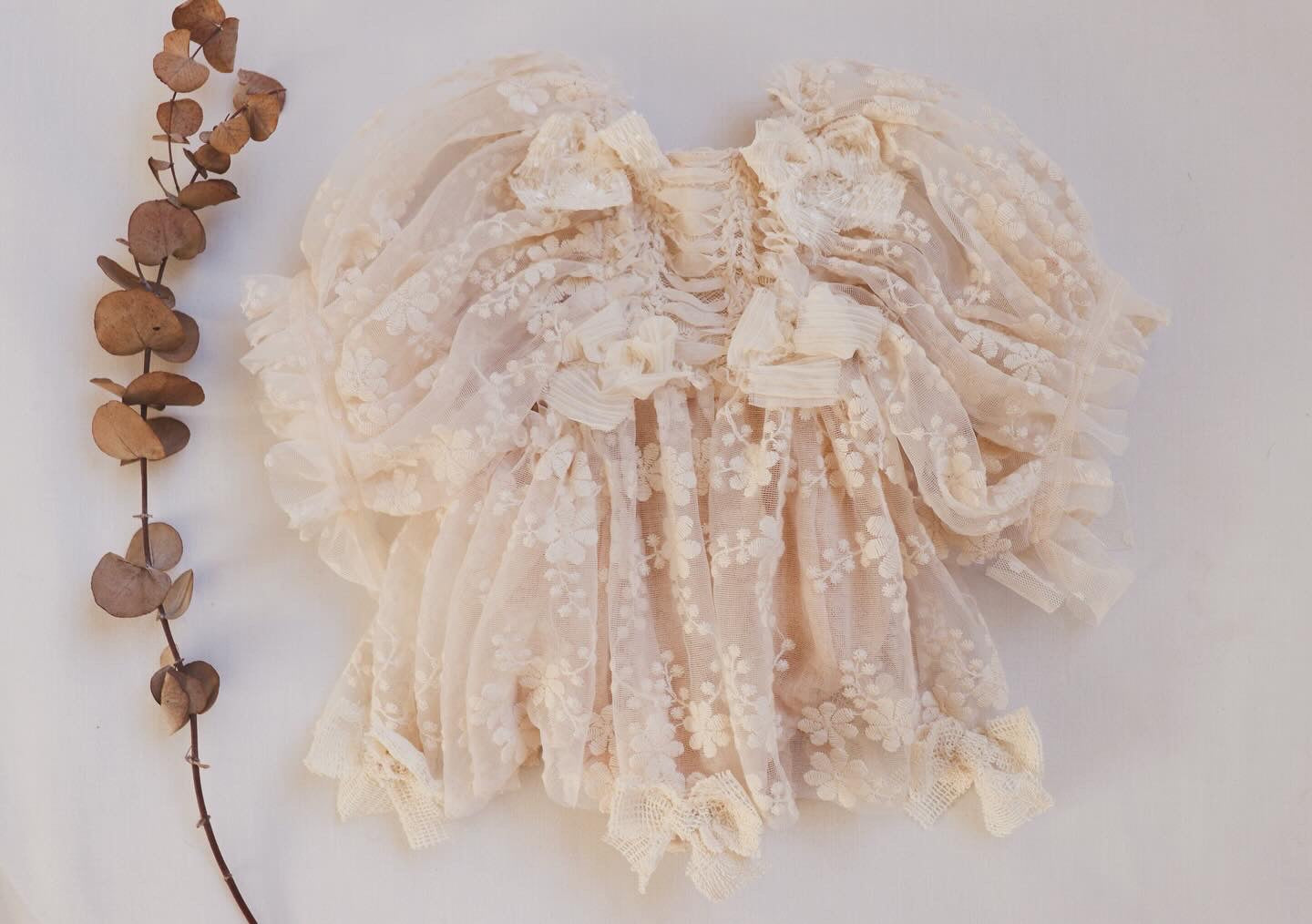 "Girl wearing a boho vintage dress with puffed embroidered sleeves and beige lace bodice during an outdoor photoshoot."


