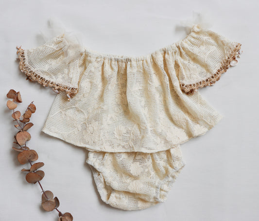 Baby girl wearing off-shoulder boho flutter top with vintage lace and shell trim, paired with matching bloomer