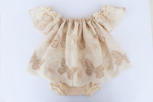 Beige lace baby romper on a white background