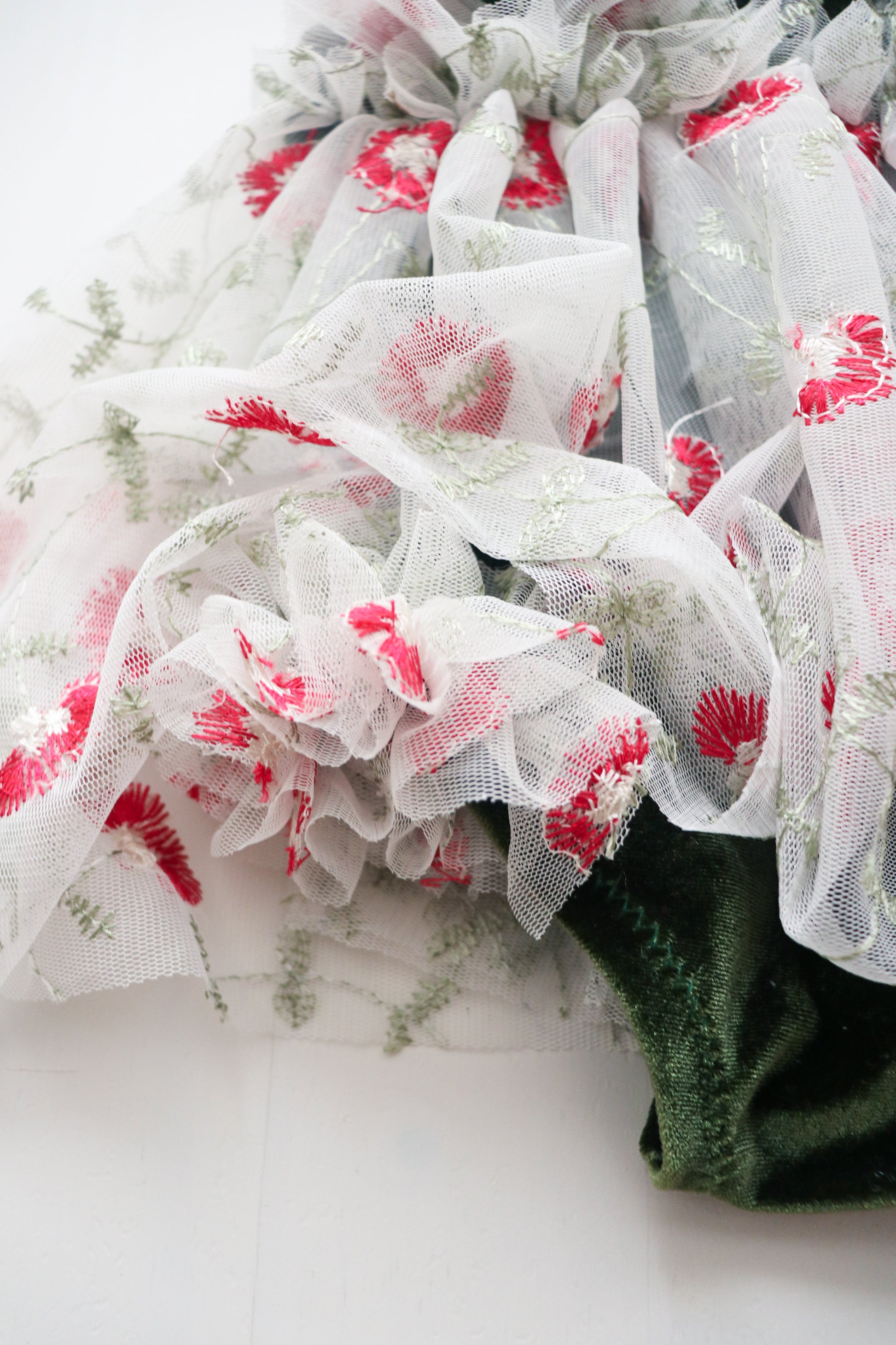 Sapin green velvet romper with festive white tulle, red flowers, and ruffles, ideal for holiday sessions