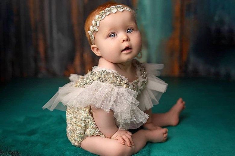 Adorned with pearls and ruffled tulle on both shoulders, this playsuit is designed for those picture-perfect memories. Ideal for weddings, baptisms, or any event where your child deserves to look and feel extraordinary.

