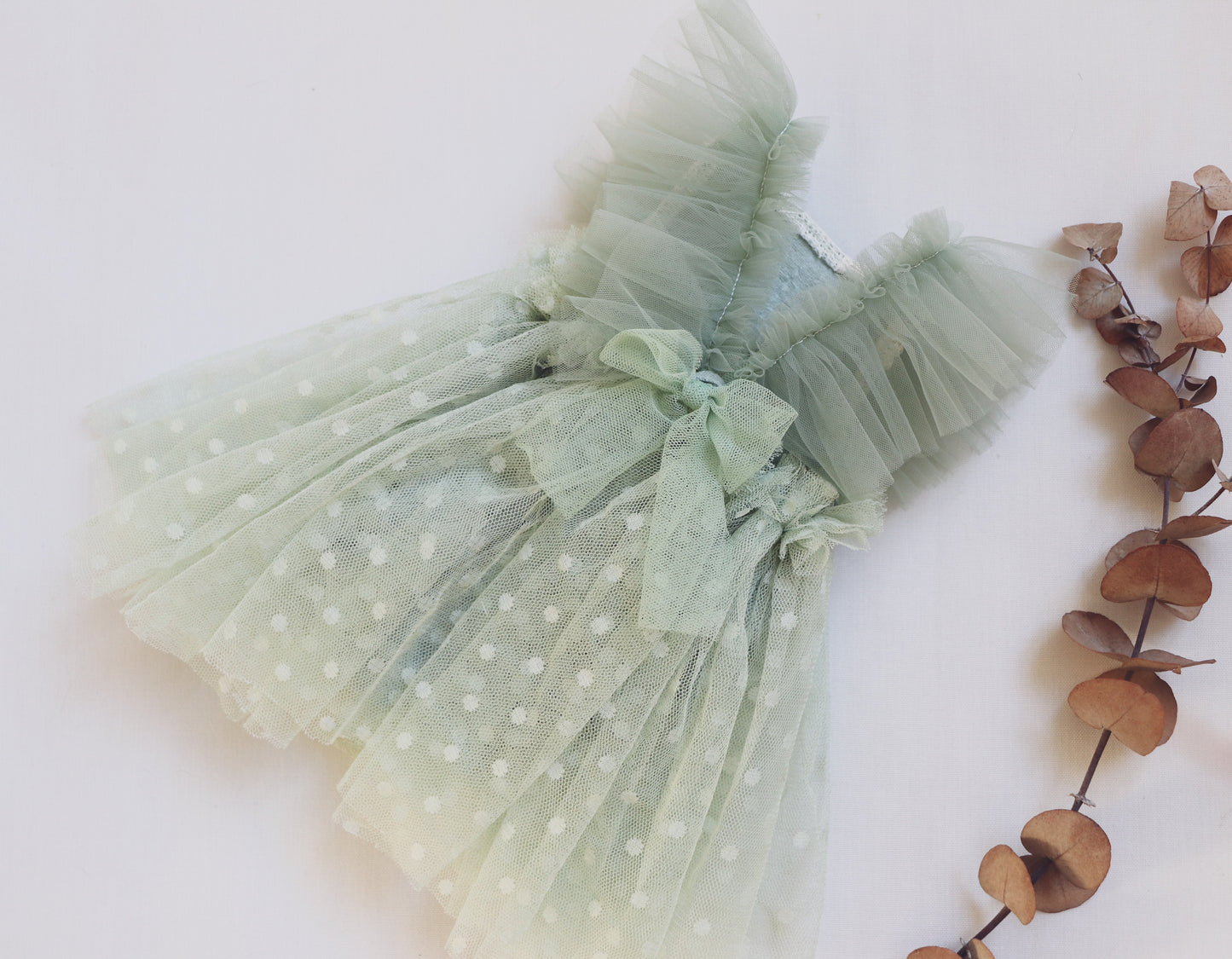 "Close-up of a dottie sage green newborn dress featuring ruffled tulle, vintage lace, and adjustable tulle straps – perfect for baby photos up to 1 month old."

