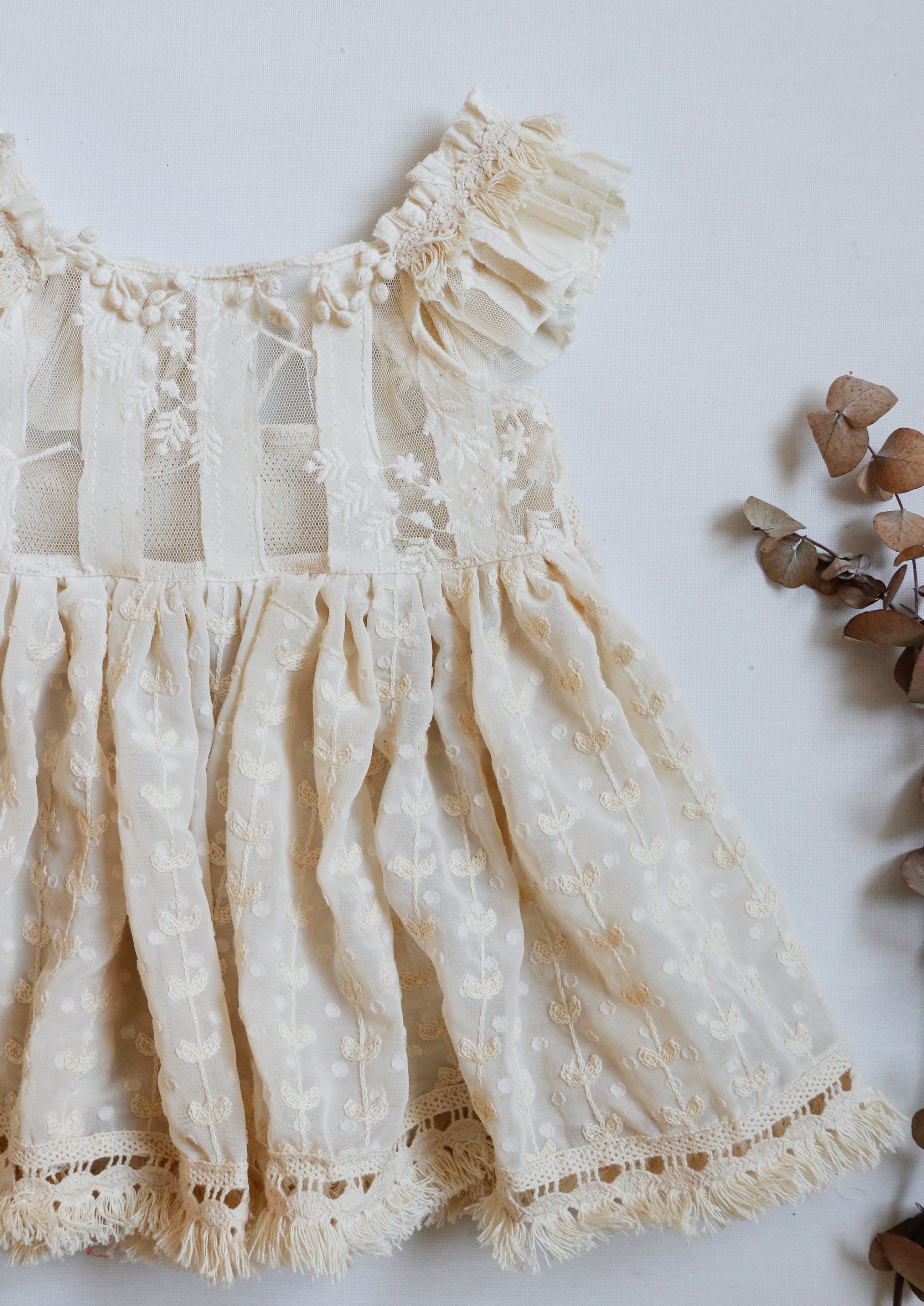 Whimsical boho girl dress with intricate lace embroidery, heart-detailed chiffon skirt, and elegant fringe accents