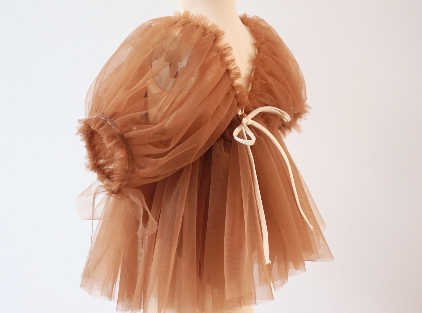 "Boho-inspired brown tulle dress for girls styled for all seasons, with embroidered flowers and vintage puffy sleeves captured in a dreamy outdoor setting."

