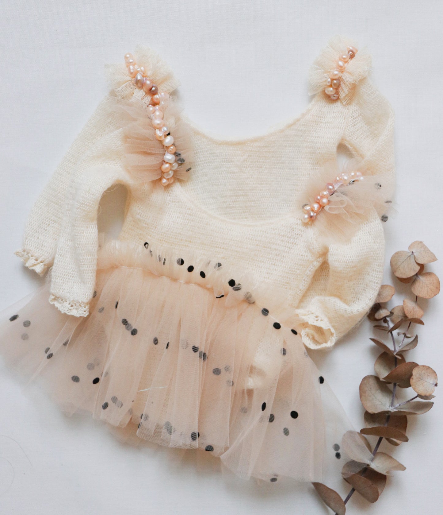 Newborn girl romper in soft ivory wool with black-dotted tulle mini skirt and freshwater pearl accents on the shoulders