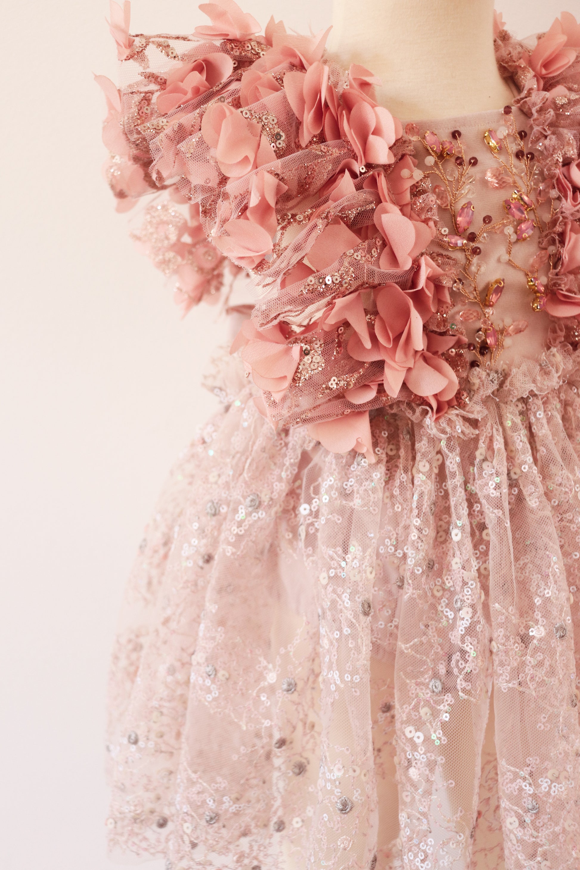 Girls' velvet dress with 3D floral petals, golden sequins on shoulders, and pink sequin skirt with silver embroidery."