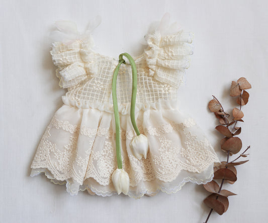 Newborn girl ivory romper with embroidered lace bodice, chiffon skirt, and ruffled lace accents – ideal for photoshoots