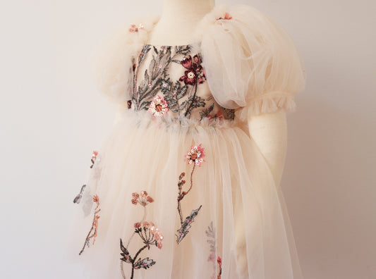 Girls' ivory dress with a velvet bodice, floral embroidery, and soft tulle skirt with puffy sleeves."