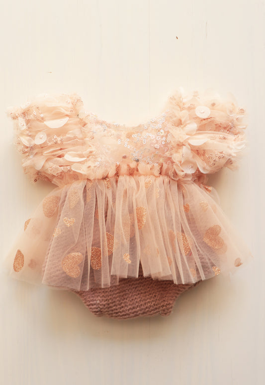 Newborn girl’s romper dress with pink pastel puffed sleeves, golden tulle skirt, and sequins bodice