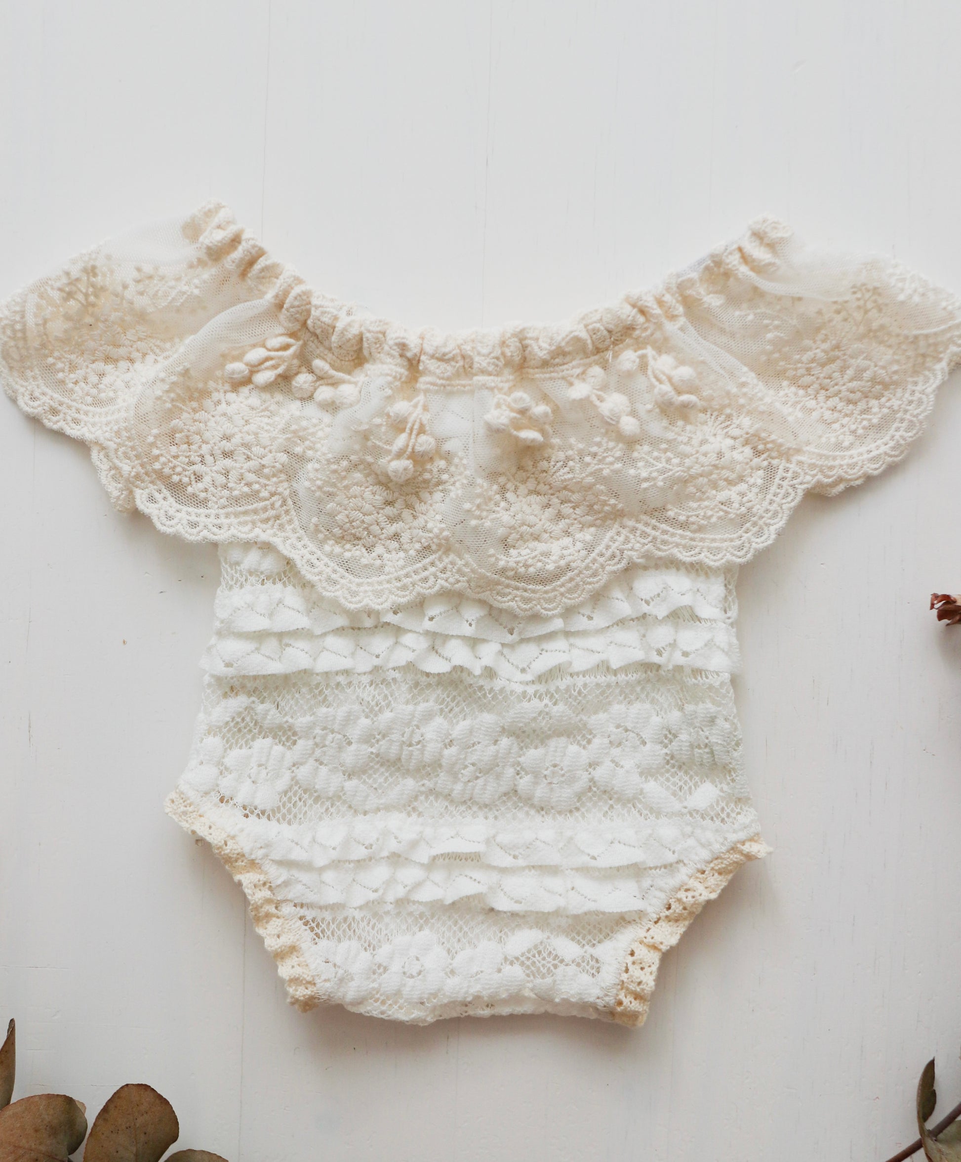 Newborn girl romper with lace and ruffled embroidery on the neckline, perfect for capturing beautiful photoshoot moments