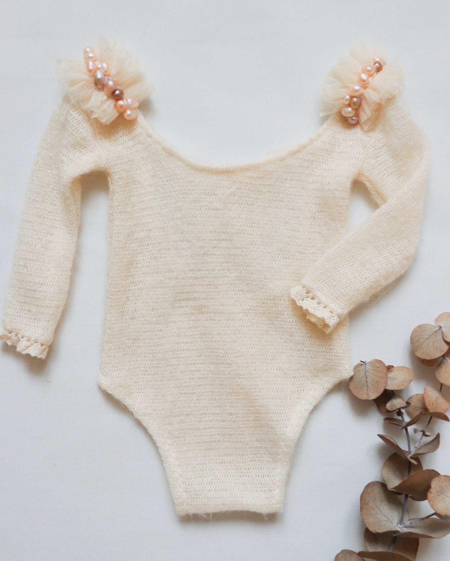 Stylish newborn romper with a black mini tulle skirt and pearl-decorated shoulders, perfect for photoshoots.