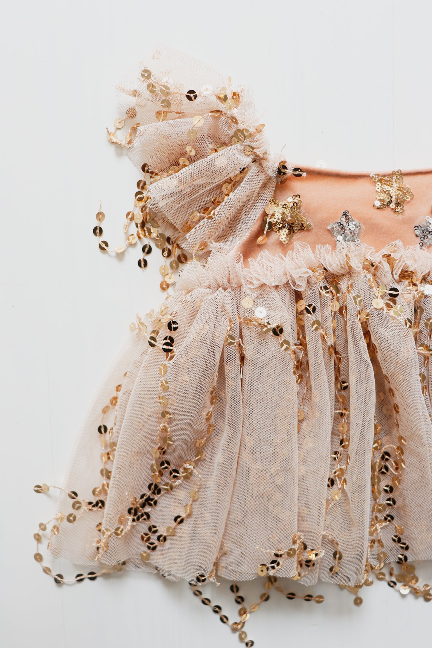 Pink peach velvet girl’s dress with golden sequin trim, ruffled tulle on shoulders, and matching bloomer