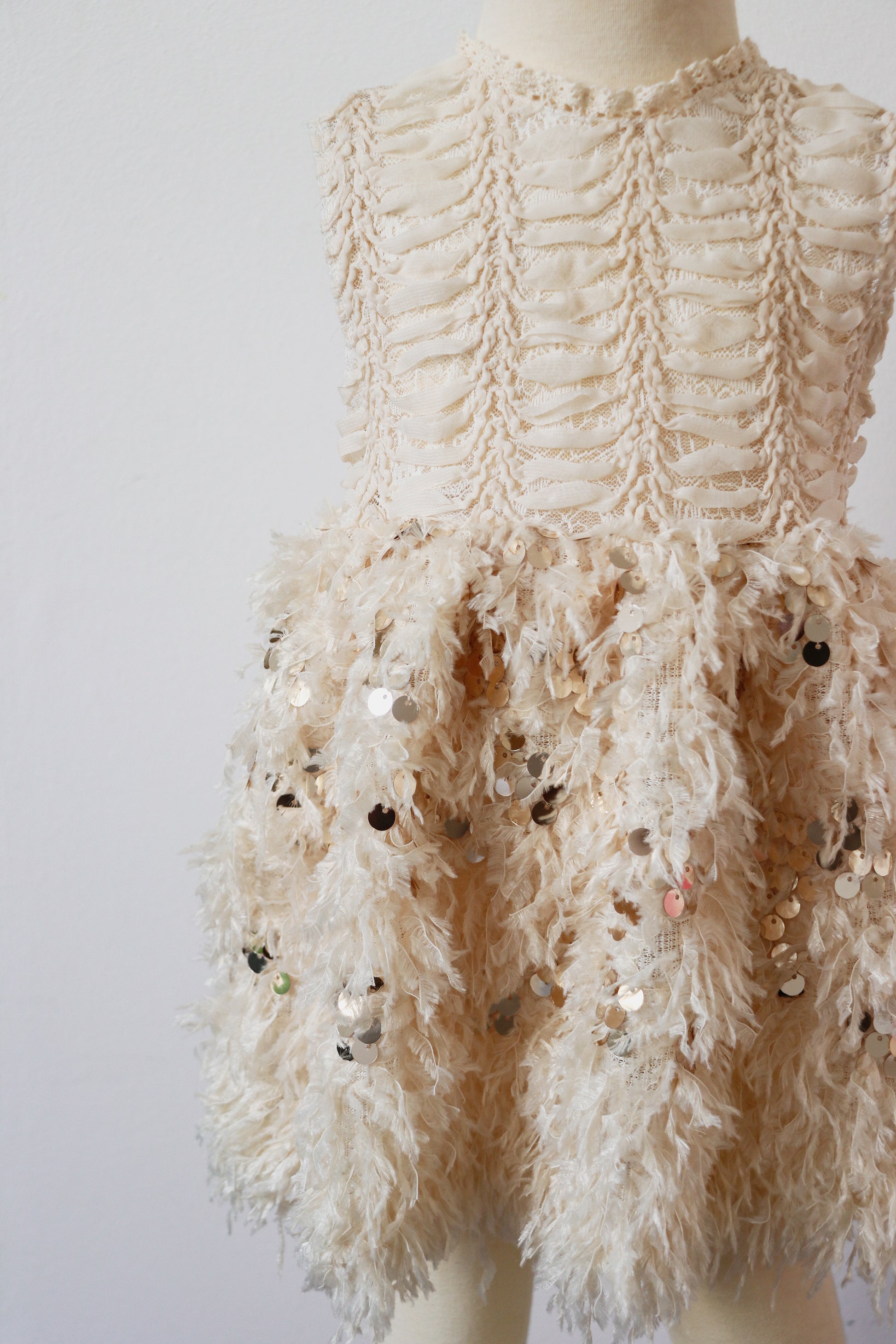 This Rococo-inspired dress features an embroidered fish bone chest and a light beige feather skirt with gold sequins, perfect for special events.