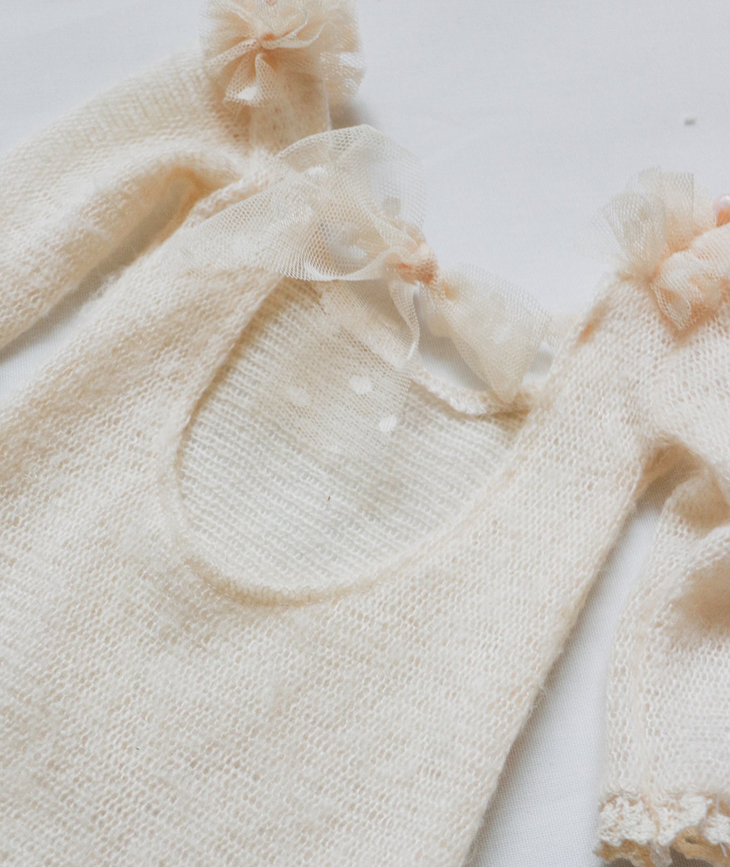 Elegant baby girl romper with soft wool fabric, ruffled tulle, and delicate pearl embellishments