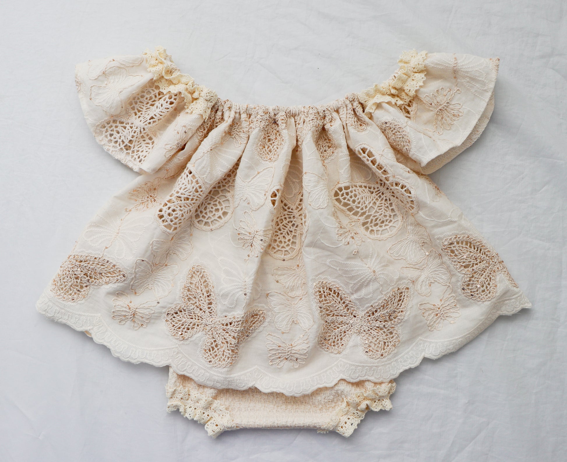 Beige cotton knit baby bloomer set with butterfly embroidery and ruffled sleeves by FLEUR MARGOT