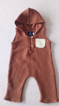 Brown knitted sleeveless hooded sitter romper for photoshoot with white pocket and wooden buttons
