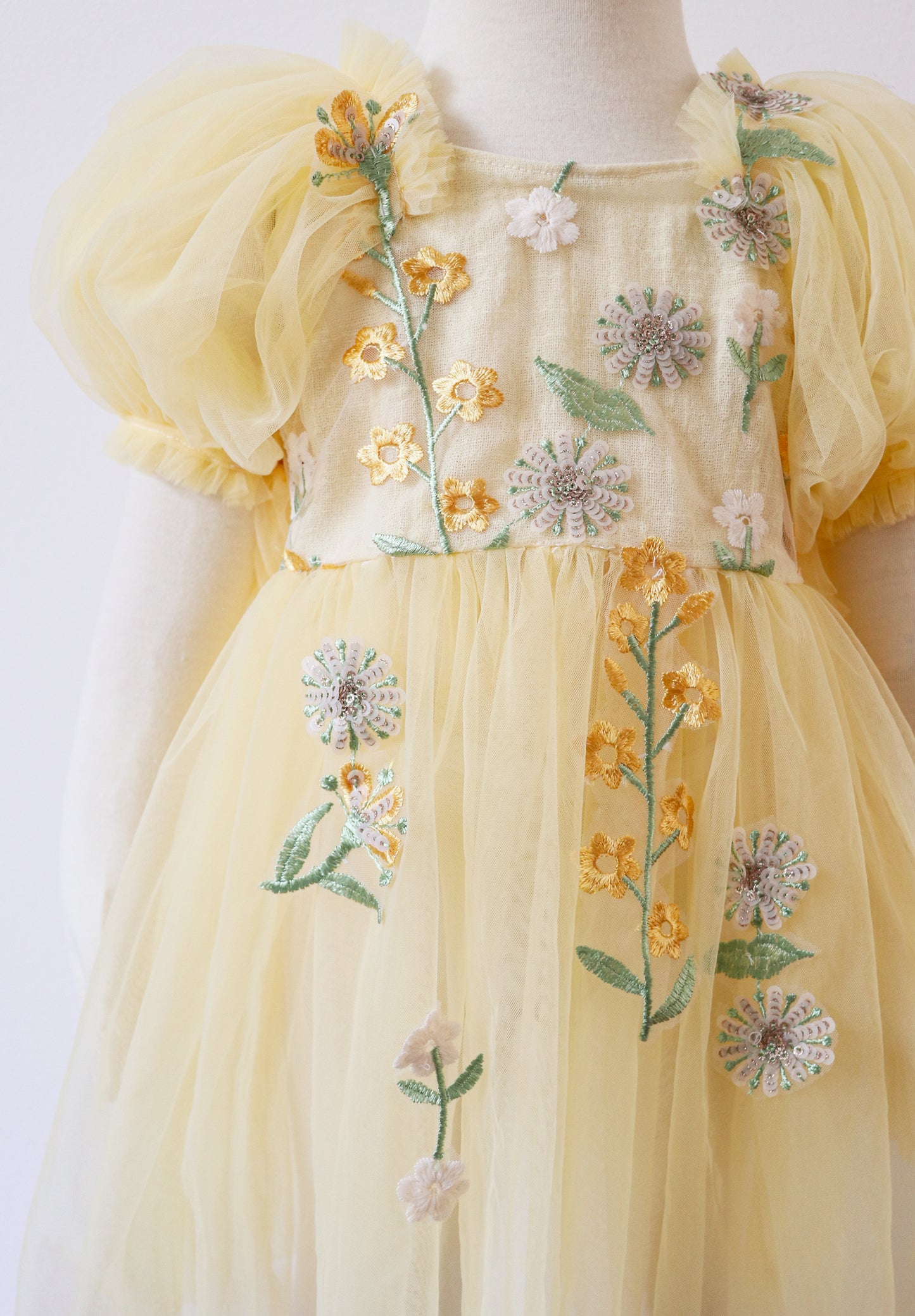 Yellow floral sitter romper dress by FLEUR MARGOT with embroidered flowers and puff sleeves for babies