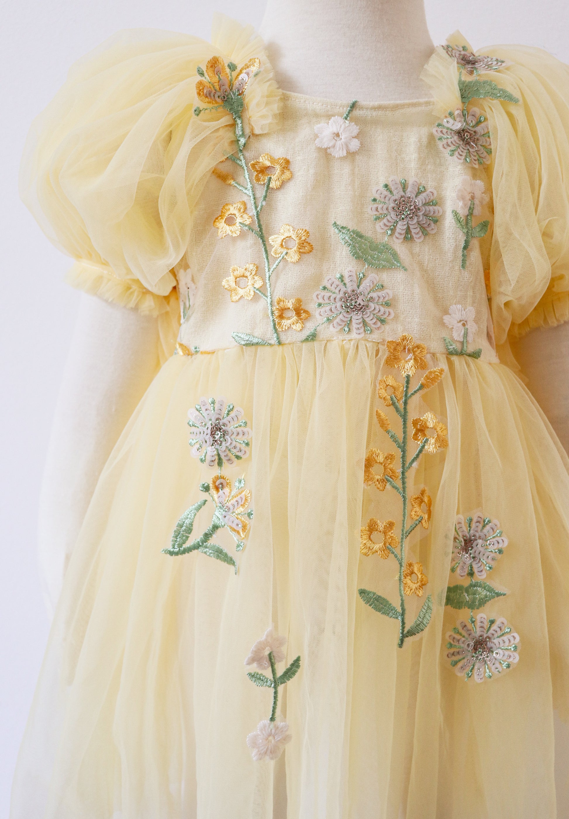 Yellow floral sitter romper dress by FLEUR MARGOT with embroidered flowers and puff sleeves for babies