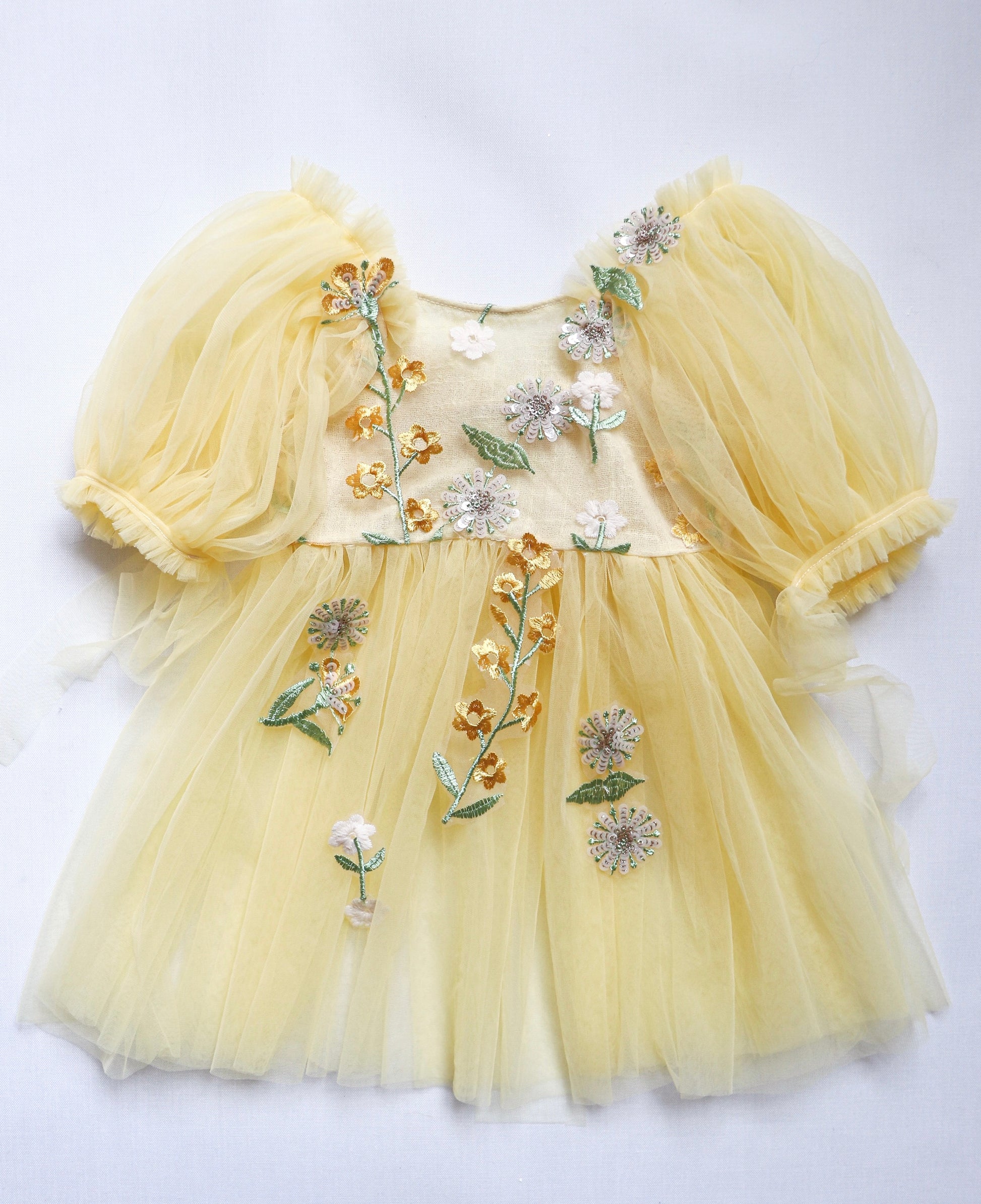 Yellow floral sitter romper dress with puff sleeves and embroidered flower details by FLEUR MARGOT