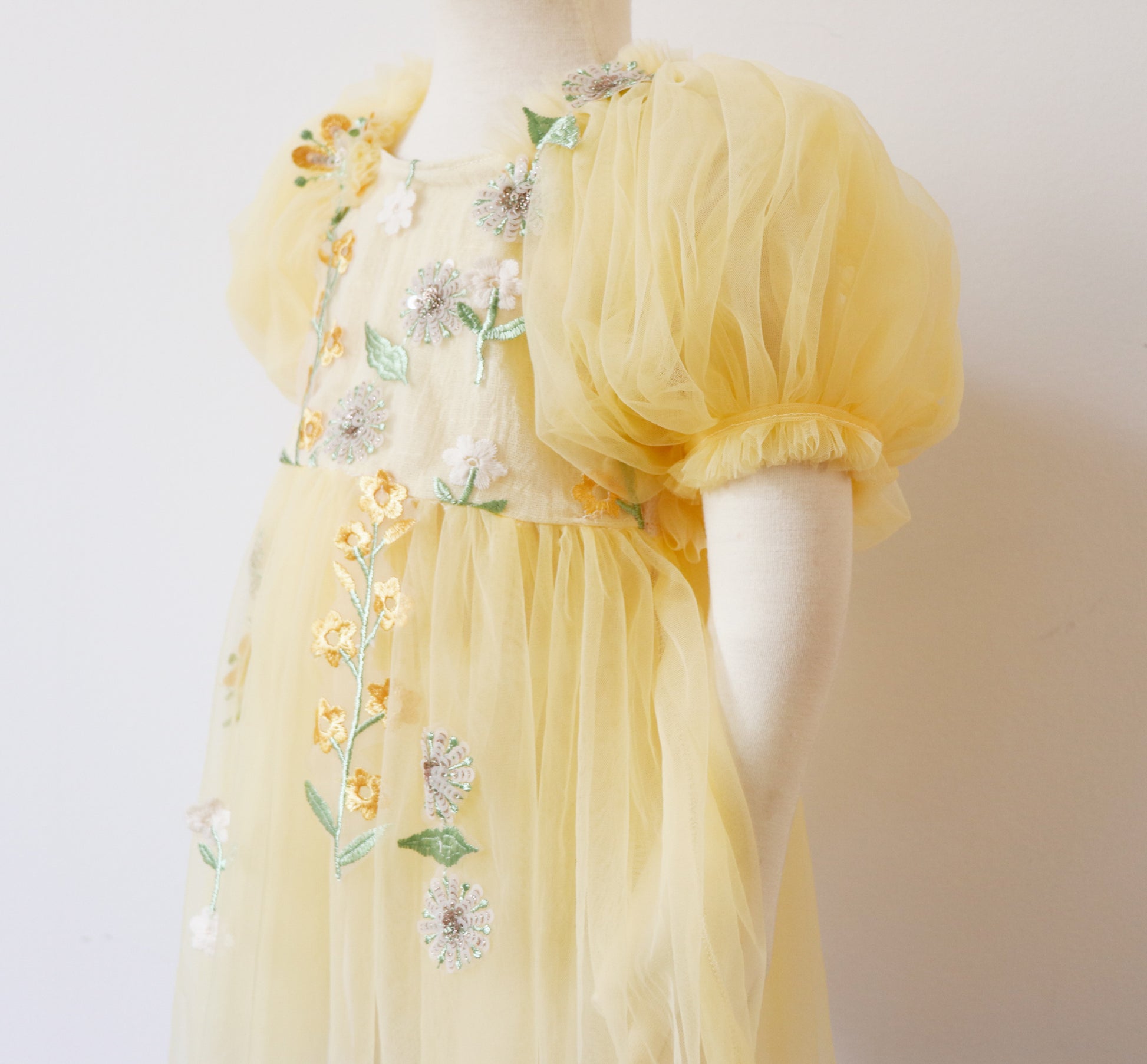 Yellow floral sitter romper dress with puff sleeves and delicate embroidered flower details by FLEUR MARGOT