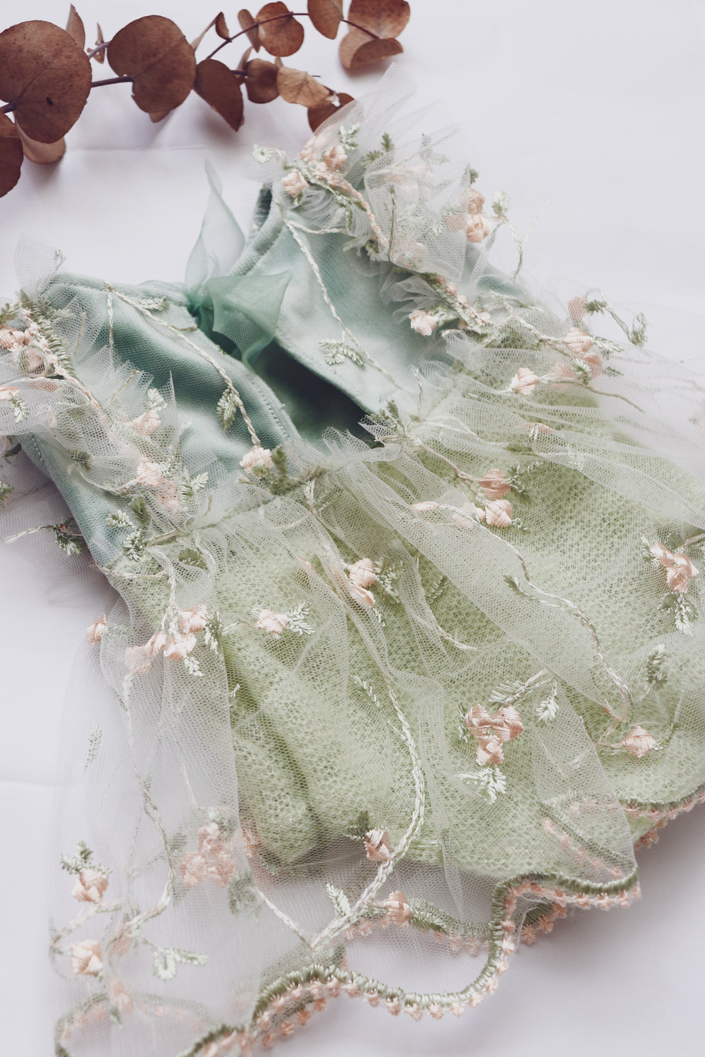 Elegant newborn dress with floral embroidery in soft green and delicate tulle details