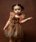 Toddler girl wearing a sitter session floral dress autumn with ruffled sleeves in warm tones