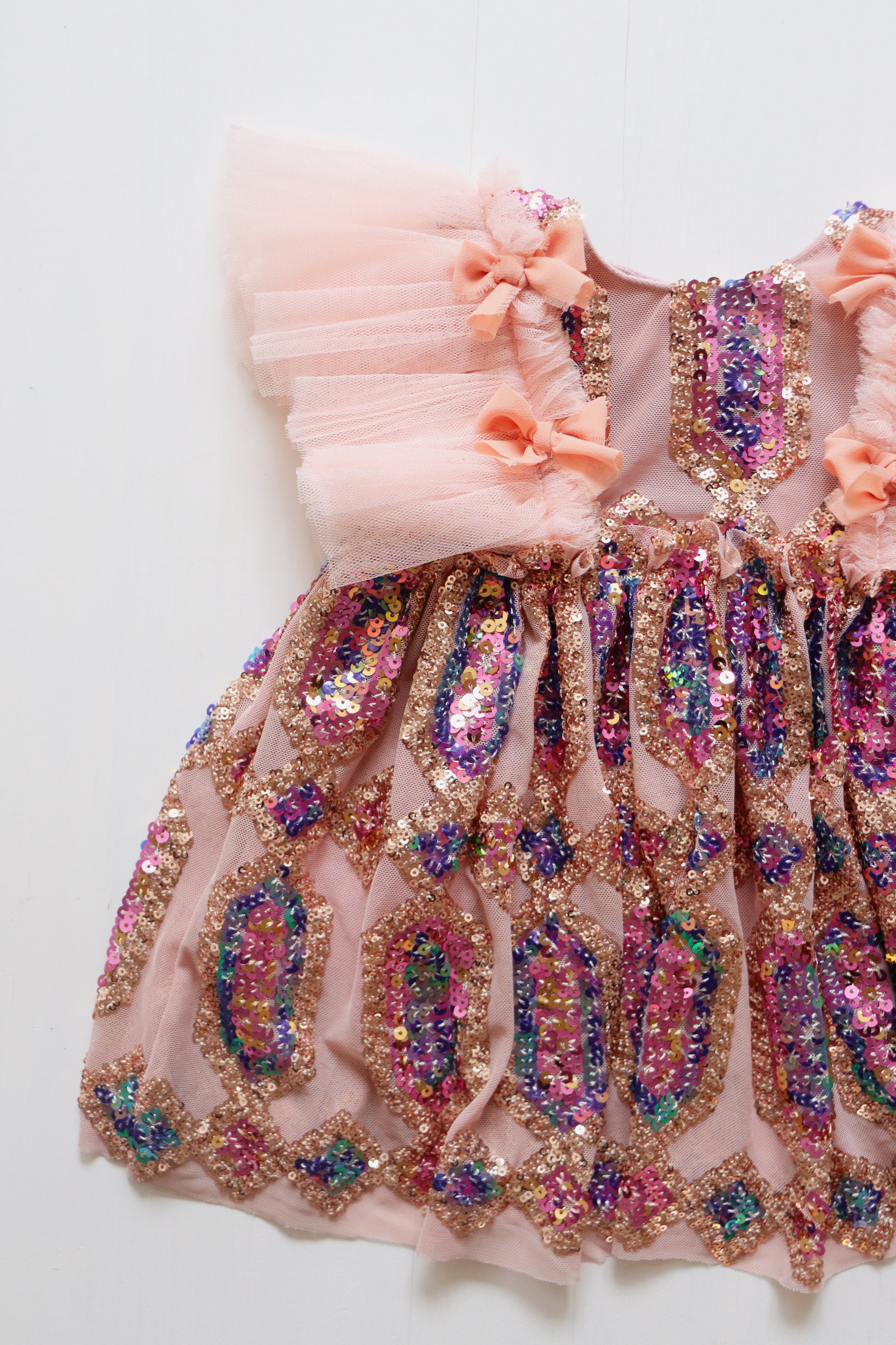 Girl's dress with colorful sequin bodice, ruffled tulle on both sides, and bow detail